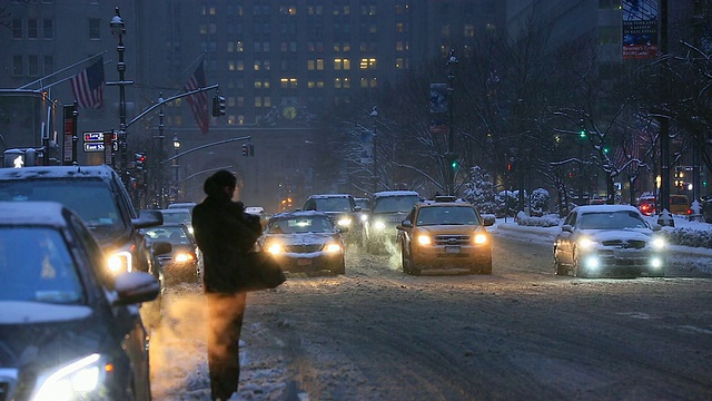 下着雪的公园大道上，摄像机拍下了曼哈顿中城的交通和通勤者。视频素材