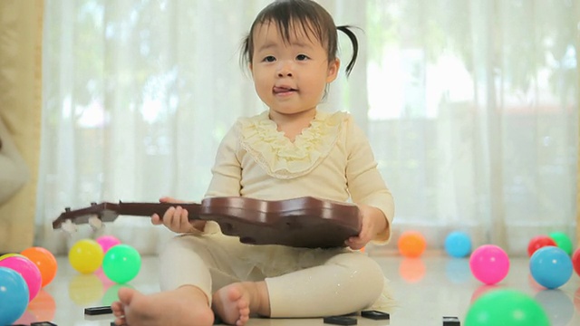 弹吉他的亚洲小女孩视频素材