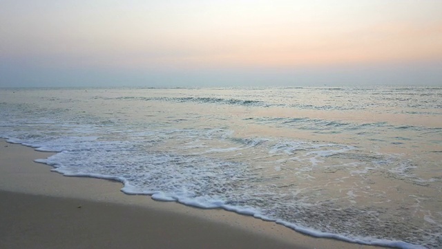 随着日出，海浪拍打在海滩上视频素材