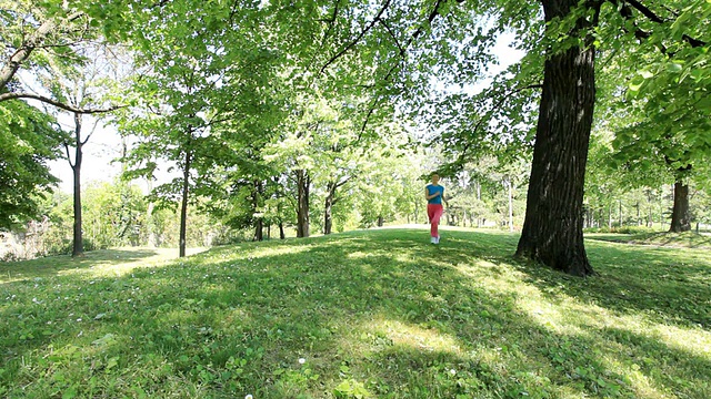 女孩在公园里跑步。视频素材