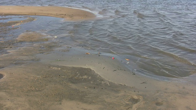 海浪拍打着沙滩上的一个小水池视频下载