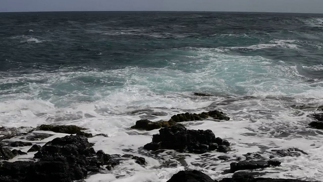 海浪拍打着黑色的熔岩视频素材