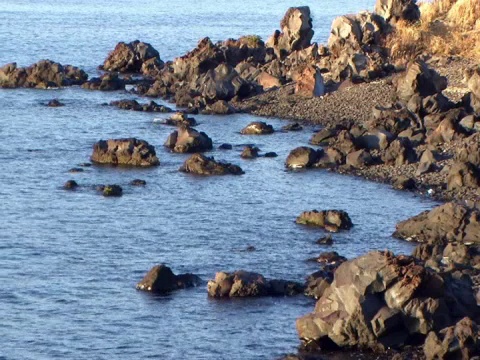 日落时海浪拍打在岩石上(视频)视频素材