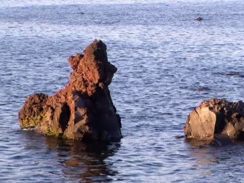 日落时海浪拍打在岩石上(视频)视频素材