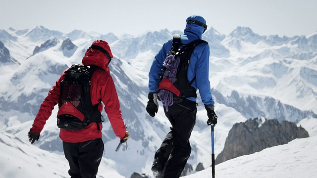 登山者在白雪覆盖的山上行走视频素材