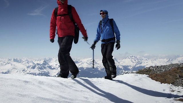 登山者在白雪覆盖的山上行走视频素材