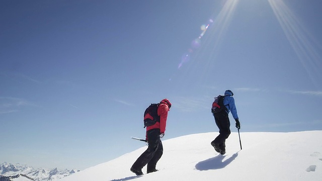 登山者在白雪覆盖的山上行走视频素材