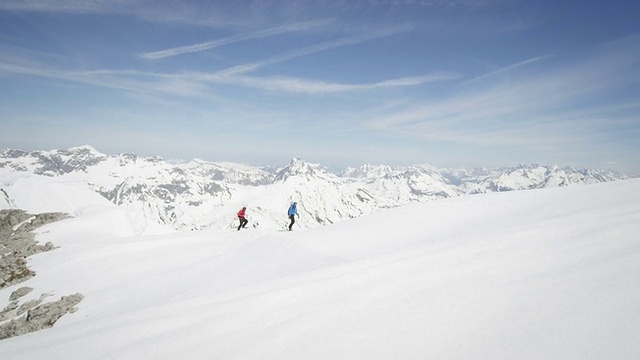 登山者在白雪覆盖的山上行走视频素材