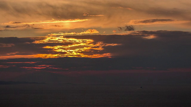 夕阳在海面上缓缓落下，一艘船正在离去视频素材