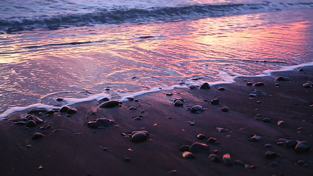 日出时海浪冲到海滩上视频素材