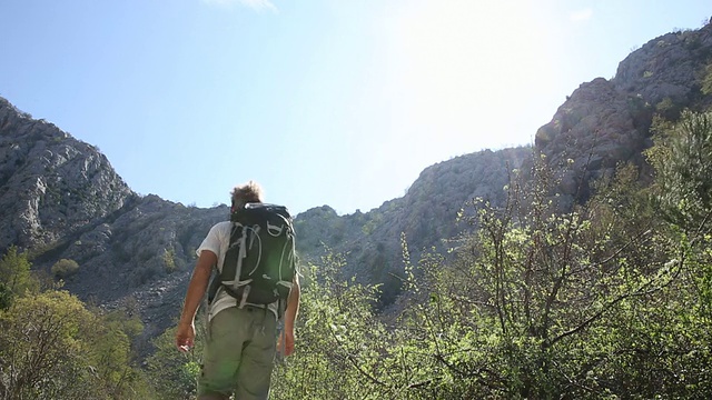 一对情侣沿着山路散步，女人在拍照视频素材