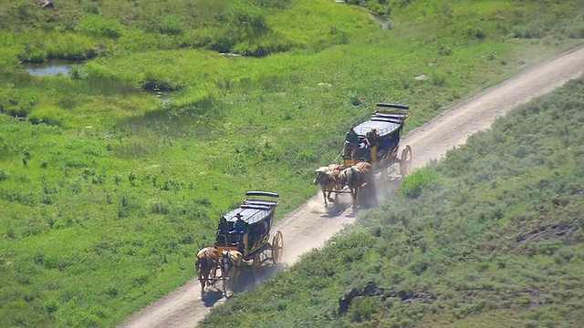 高空俯瞰在泥土路上奔跑的马车/怀俄明州，美国视频素材