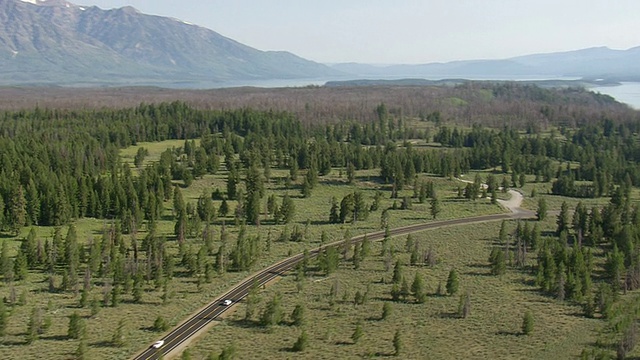 美国怀俄明州，在高速公路和高山冰川森林上行驶的WS AERIAL DS汽车视频素材