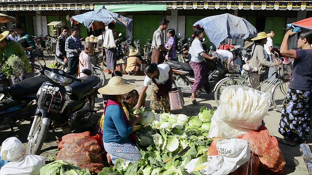 缅甸掸邦年瑞当地市场，女士骑着自行车卖蔬菜视频素材