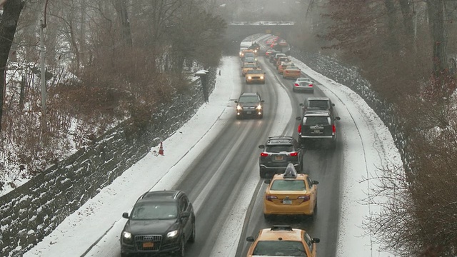 在一个大雪纷飞的冬日里，纽约中央公园的街道上，交通拥挤。视频素材