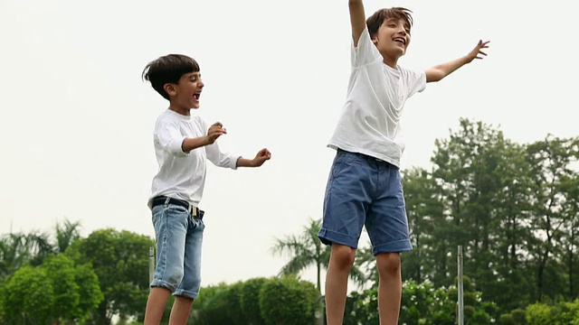 两个男孩在蹦床上跳视频素材