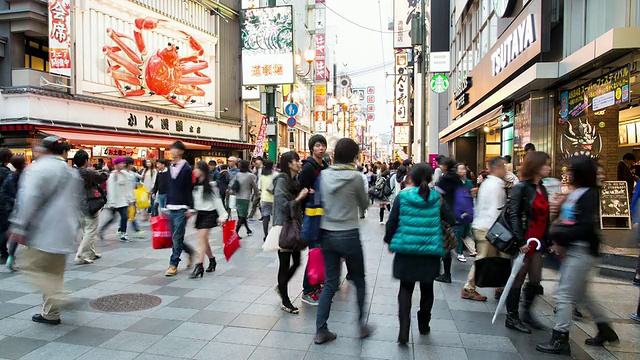 日本大阪，购物者穿过大阪市中心经过巨型机械蟹视频素材