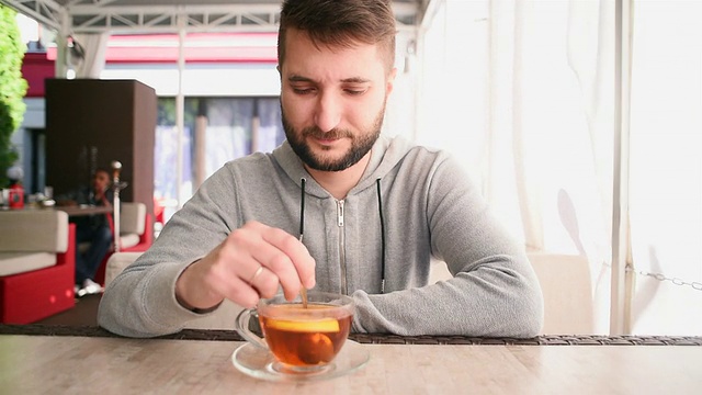 年轻的大胡子男子在咖啡馆喝茶视频素材