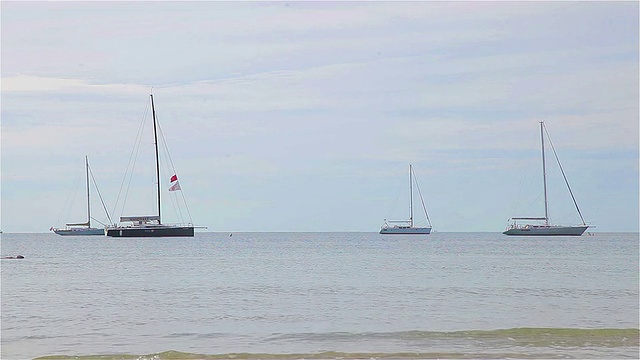 一艘小型游船停泊在海滩附近的海上。视频素材