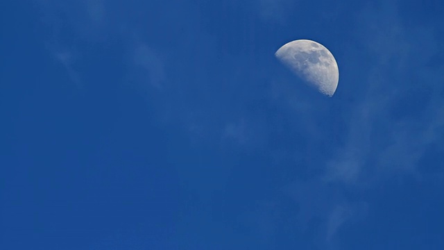 四分之一的月亮和云在蓝色的天空中移动/波利赫海滩，夏威夷考艾岛，美国视频素材