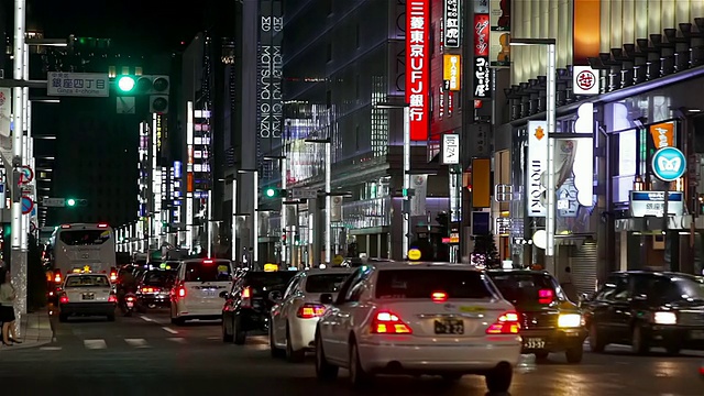 MS拍摄的街道十字路口，汽车和出租车在夜间穿过大尺度区域/日本东京视频素材