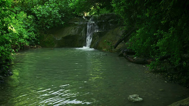 瀑布从岩石上倾泻到小泉水视频素材