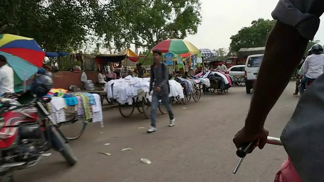 在印度一个老城区的街道上，从一辆人力车的后面看到的时光流逝的景象视频素材