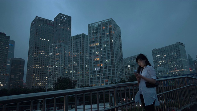 亚洲女商人在城市夜晚使用智能手机视频素材