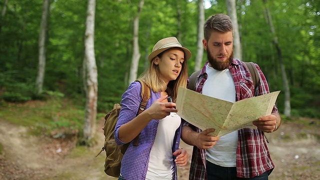 一对徒步旅行者在森林里制定一个徒步旅行地图的计划视频素材