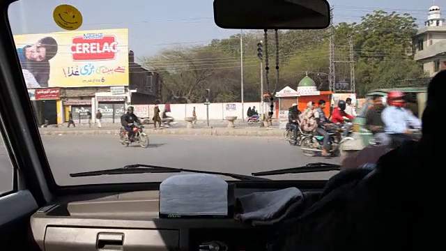 开车穿过拉合尔的街道，经过摩托车，嘟嘟车，汽车等。视频素材