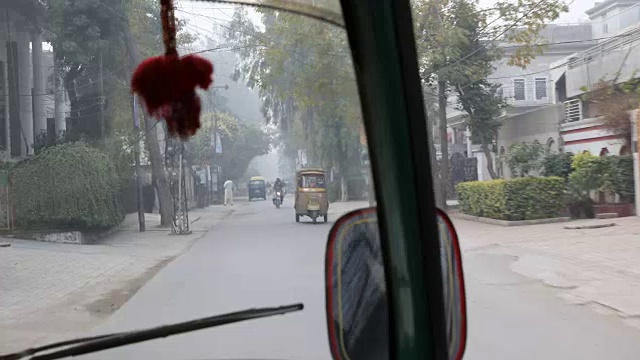 开车穿过拉合尔的街道，经过摩托车，嘟嘟车，汽车等。视频素材