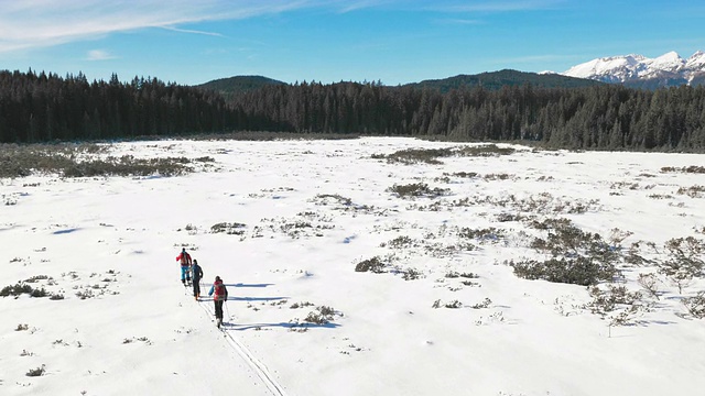 航拍的冬季登山者走过雪谷视频素材