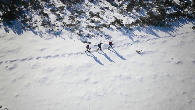 空中滑雪游客沿着山间小路滑雪视频素材