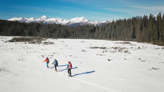 航拍的登山者在雪谷上行走视频素材