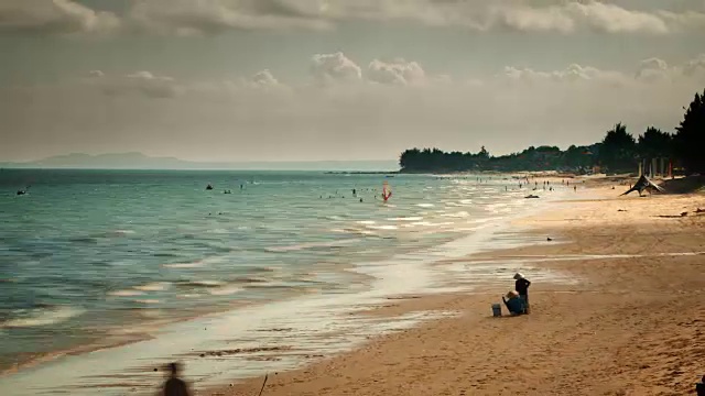 碧蓝的海水轻轻拍打着宽阔的热带海湾的沙滩视频素材