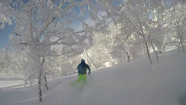 一名年轻男子滑雪在白雪覆盖的山上。——慢动作视频素材