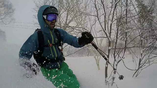 一名年轻男子滑雪在白雪覆盖的山上。——慢动作视频素材