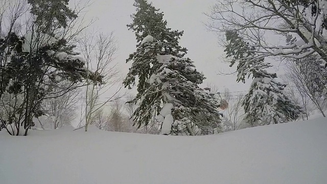 一名年轻男子滑雪在白雪覆盖的山上。视频素材