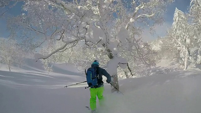 一名年轻男子滑雪在白雪覆盖的山上。视频素材