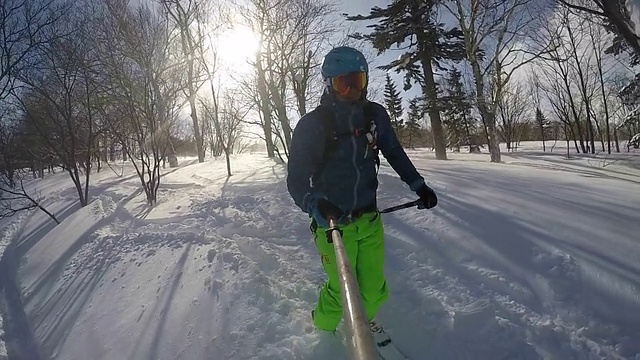 一名年轻男子滑雪在白雪覆盖的山上。视频素材