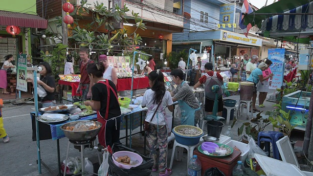 妇女们在夜市的一个食品摊上做饭视频素材