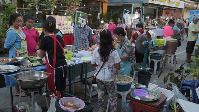 妇女们在夜市的一个食品摊上做饭视频素材