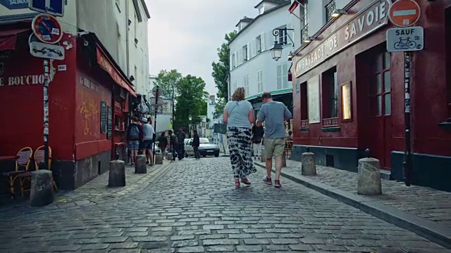 跟踪拍摄典型的蒙马特街道，礼品店和餐馆，路过的游客视频素材