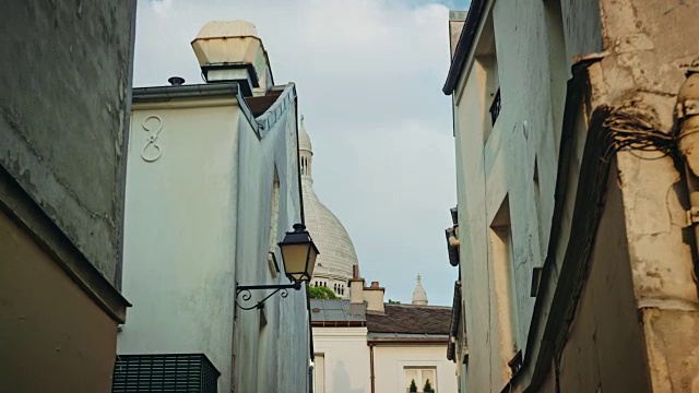 蒙马特狭窄街道的跟踪拍摄，Sacré-Coeur Basilica在背景视频素材