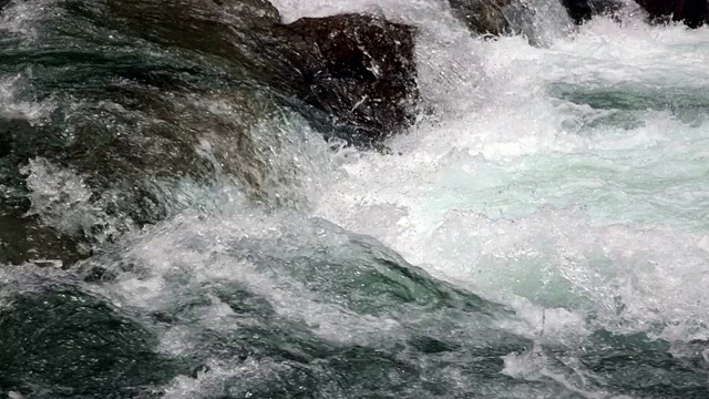 湍急的河水越过岩石的特写镜头。视频素材