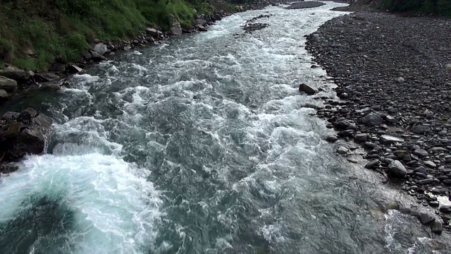 奔腾的河流沿着山谷底部在山区的潘拍摄。视频素材