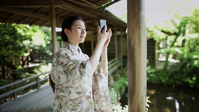 在宁静花园拍照的女人视频素材