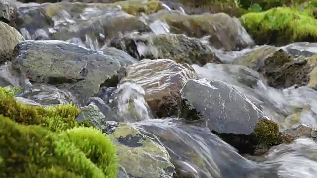 水流在喜马拉雅山脉的岩石上，岩石周围聚集着苔藓视频素材