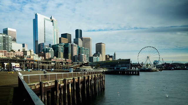 这是一幅从西雅图海滨拍摄的艾略特湾(Elliott Bay)白天的照片，上面有低垂的云层，西雅图的天际线、摩天轮(Great Wheel)、港湾岛(Harbor Island)、西西雅图和奥运会。视频素材