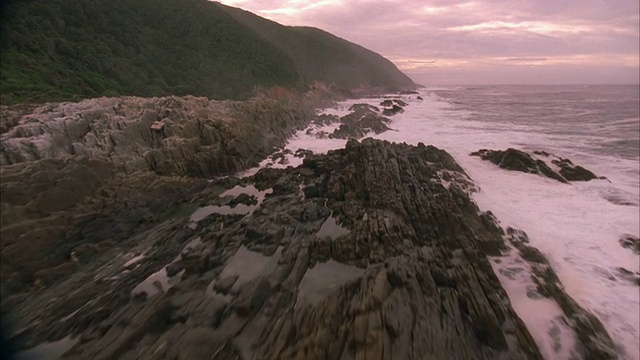 海浪撞击岩石海岸的慢动作空中拍摄视频素材